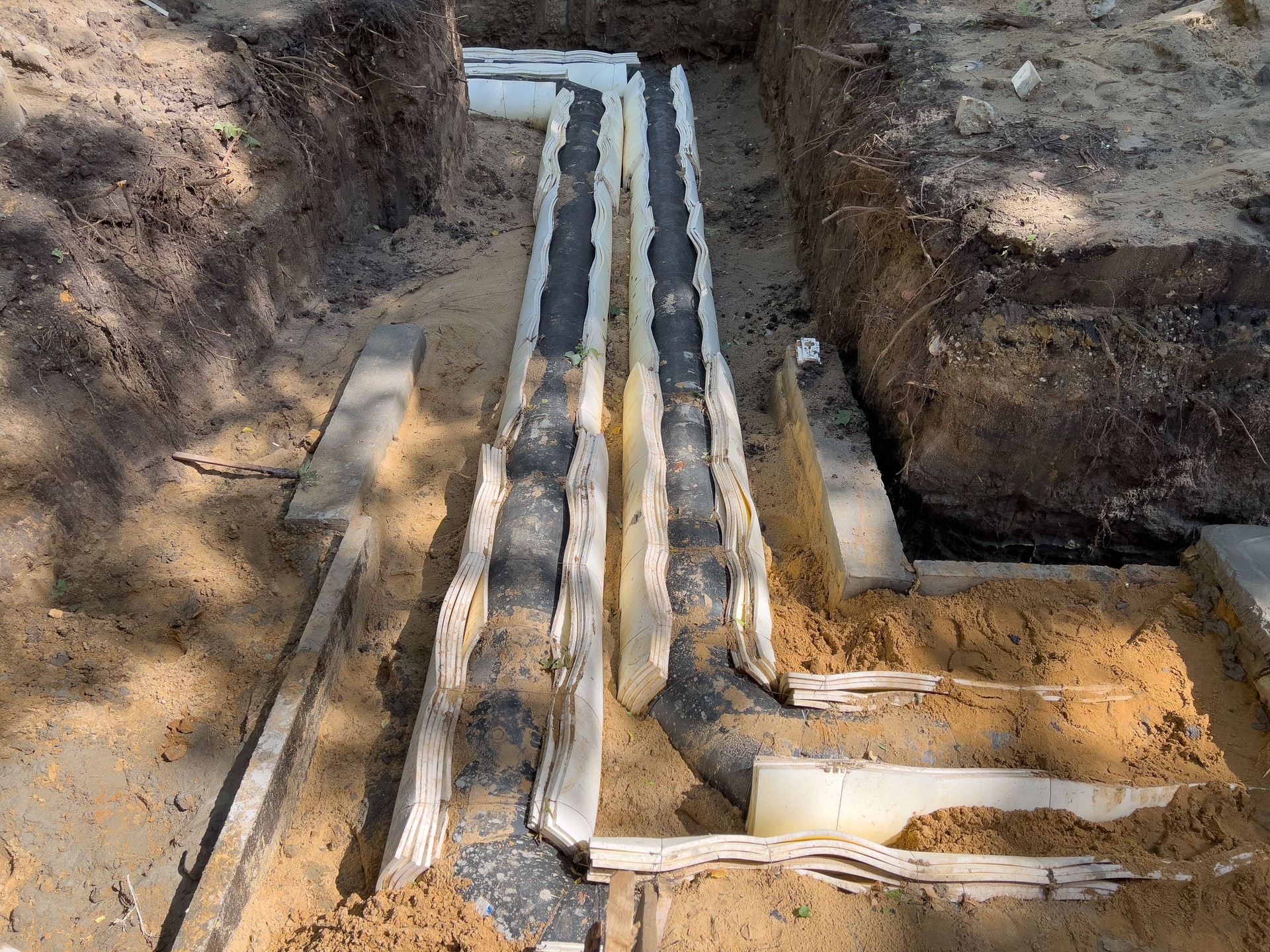 Laying a water pipe in a trench in the ground with insulation.